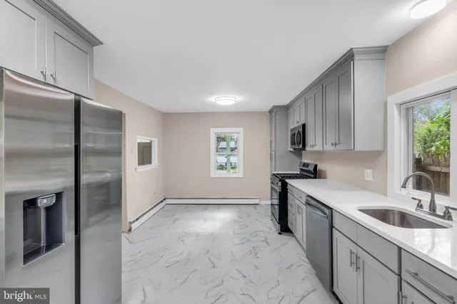 a kitchen with stainless steel appliances granite countertop white cabinets a sink and dishwasher
