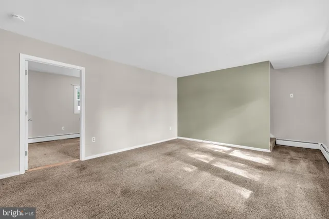 a view of an empty room and a kitchen