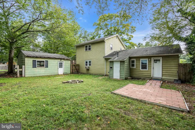 a view of a house with backyard and a tree
