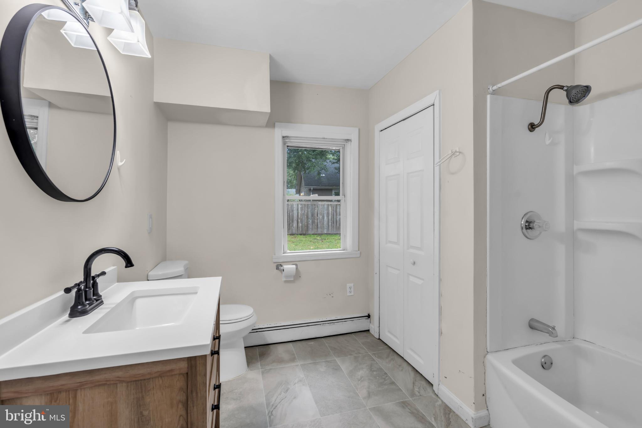 102 Sunset Street Browns Mills, NJ 08015 - Photo 8 of 27 a bathroom with a sink a toilet and a mirror