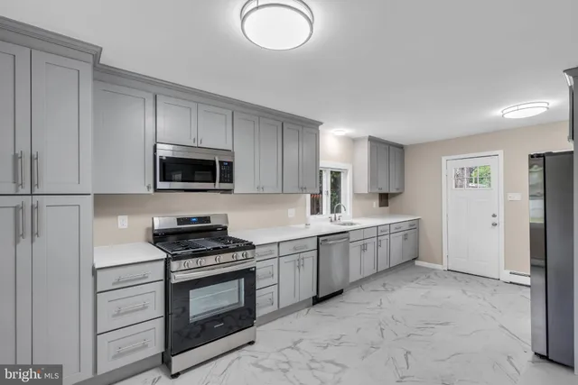 a kitchen with granite countertop a sink stainless steel appliances and cabinets
