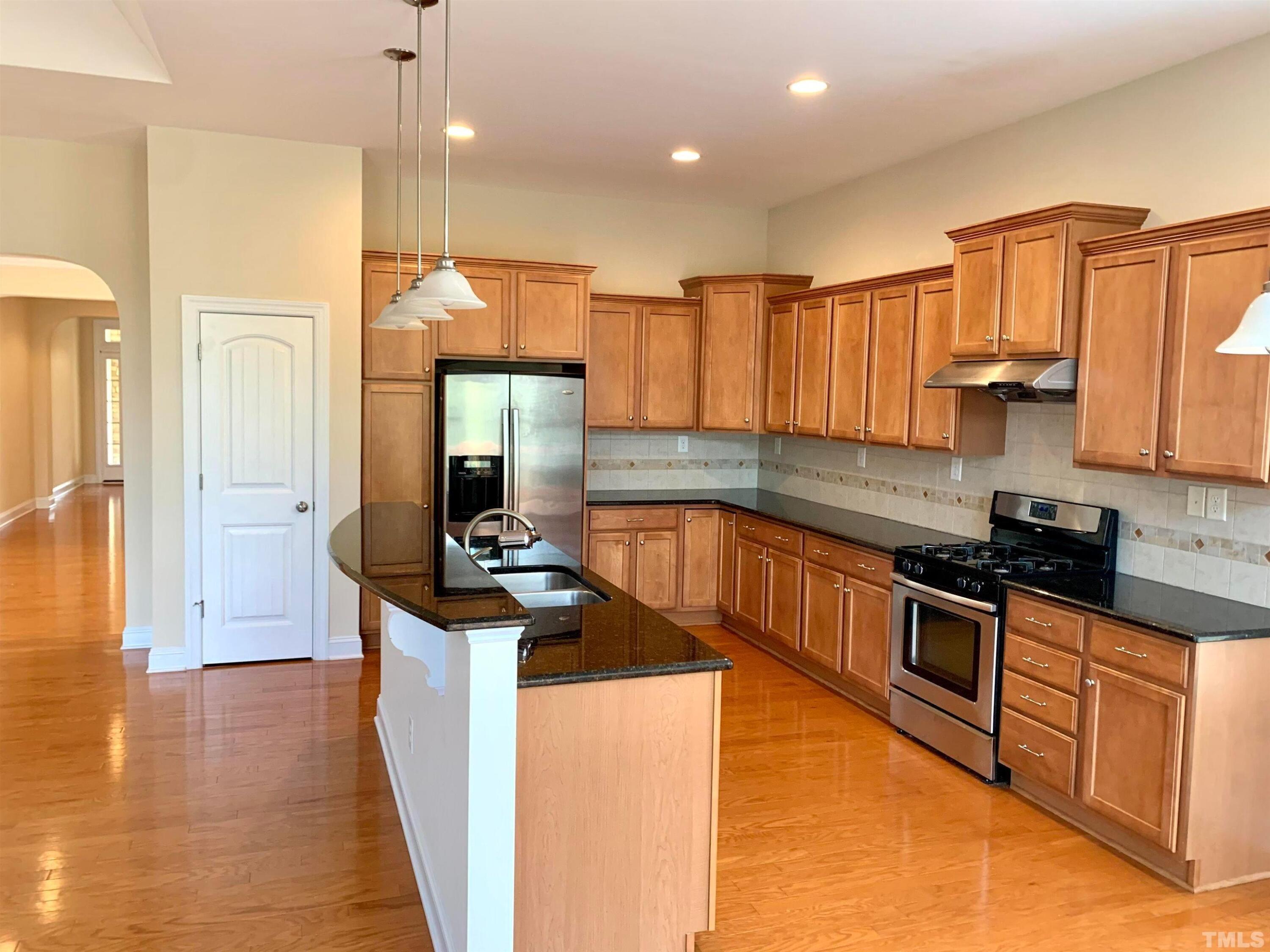 706 Weavers Ridge Drive Cary, NC 27519 - Photo 2 of 14 a kitchen with stainless steel appliances granite countertop a stove a sink and a refrigerator