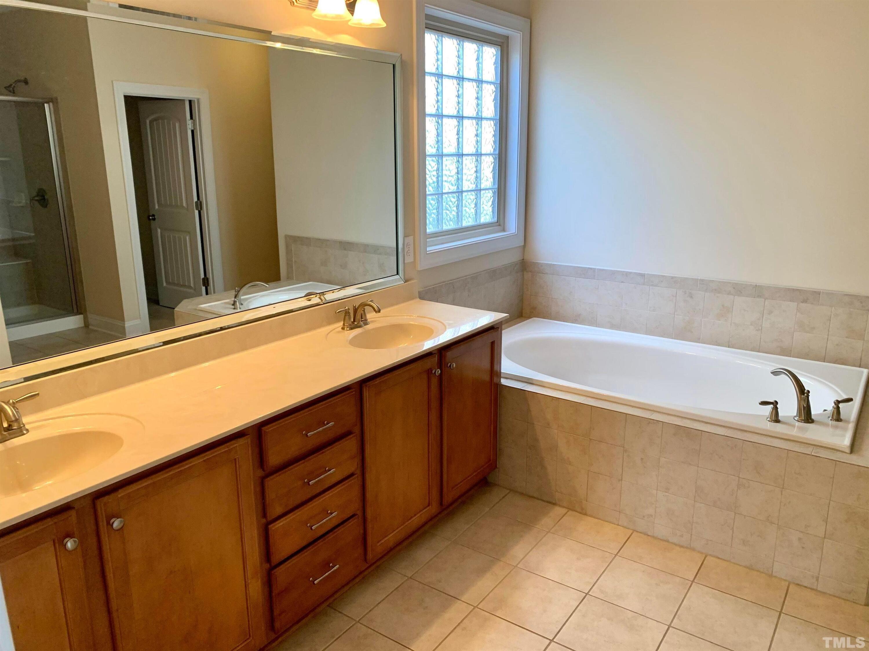 706 Weavers Ridge Drive Cary, NC 27519 - Photo 10 of 14 a bathroom with a tub sink and mirror