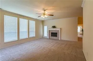an empty room with windows and fireplace