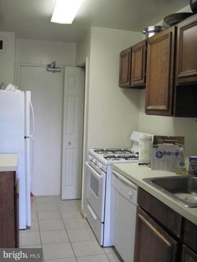 1900 Lyttonsville Road, Unit 1011 Silver Spring, MD 20910 - Photo 7 of 10 a kitchen with a stove sink and refrigerator