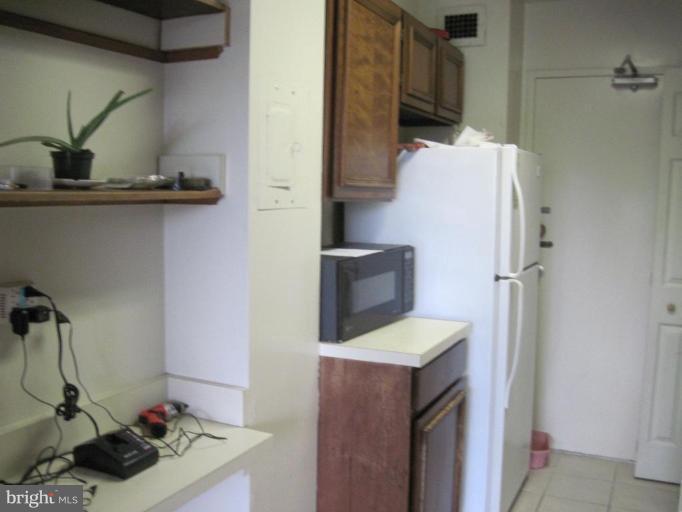 1900 Lyttonsville Road, Unit 1011 Silver Spring, MD 20910 - Photo 8 of 10 a sink a microwave and a refrigerator in a kitchen