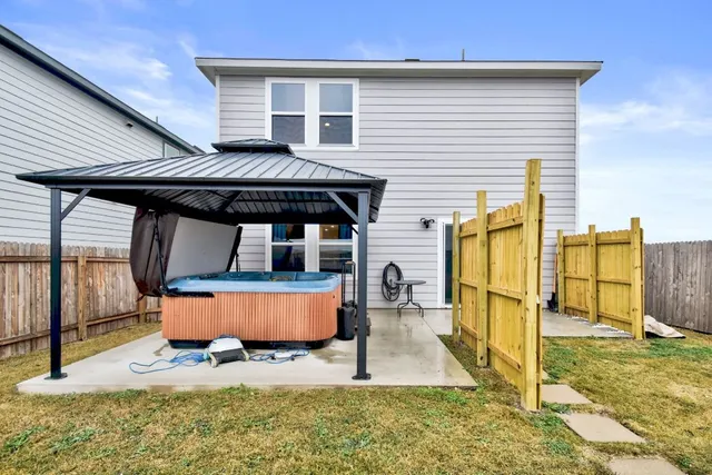 a view of a house with backyard and wooden fence
