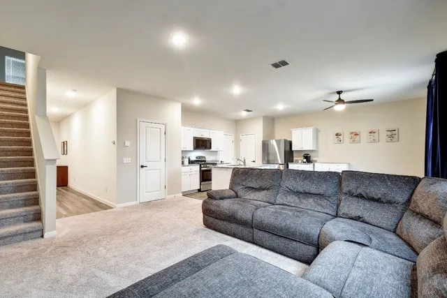 a living room with furniture and kitchen view