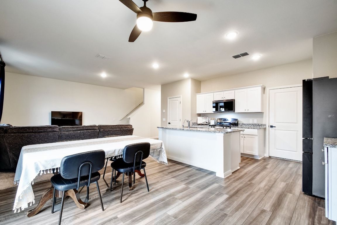 414 Plateau Street Maxwell, TX 78656 - Photo 25 of 25 a kitchen with stainless steel appliances a dining table chairs refrigerator and sink