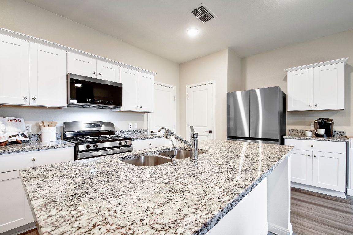 414 Plateau Street Maxwell, TX 78656 - Photo 6 of 25 a kitchen with stainless steel appliances granite countertop a stove refrigerator sink and cabinets