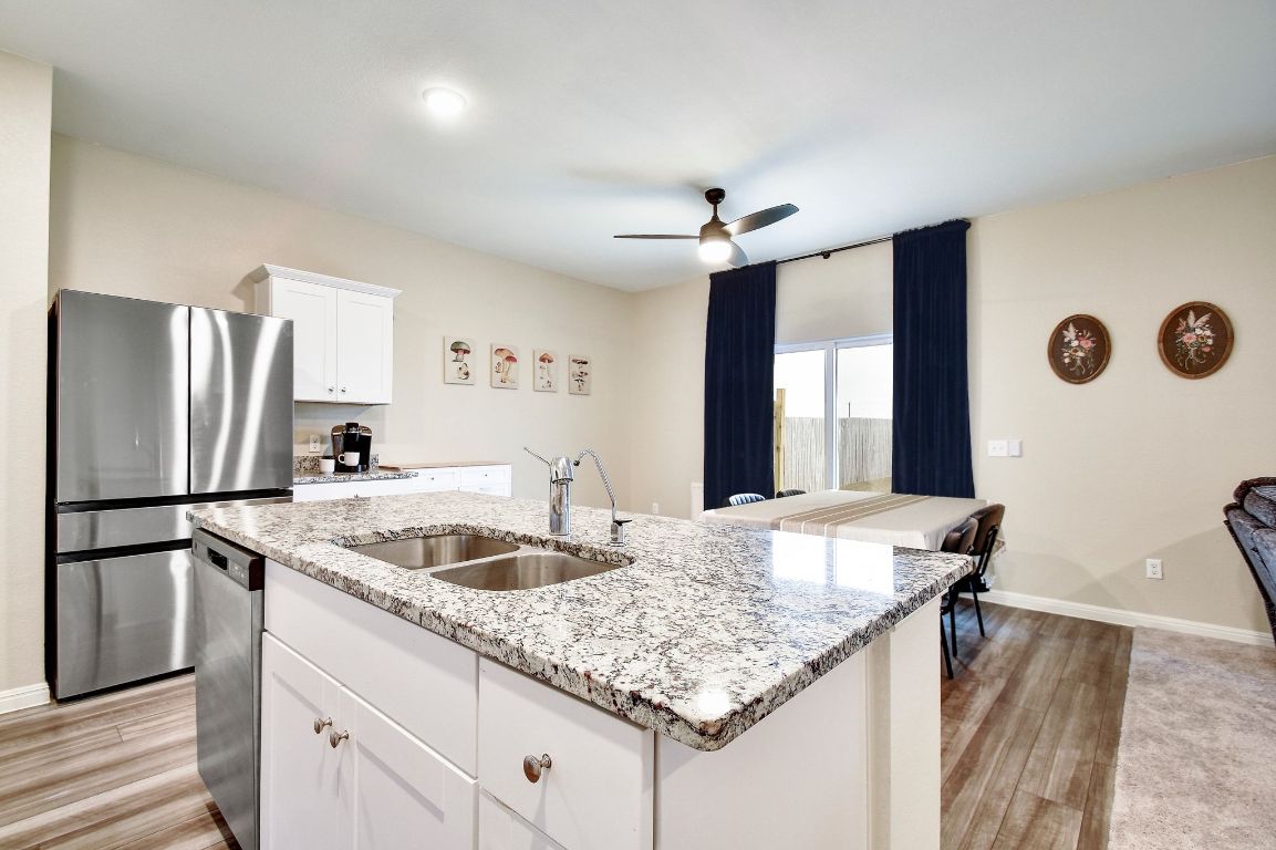 414 Plateau Street Maxwell, TX 78656 - Photo 7 of 25 a kitchen with stainless steel appliances granite countertop a sink refrigerator and microwave