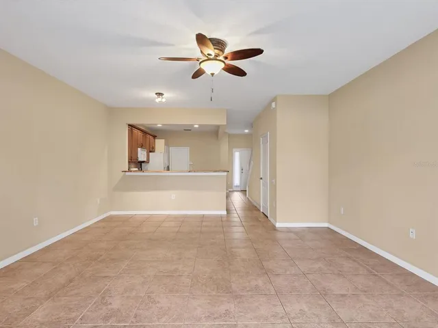a view of an empty room with a ceiling fan and window