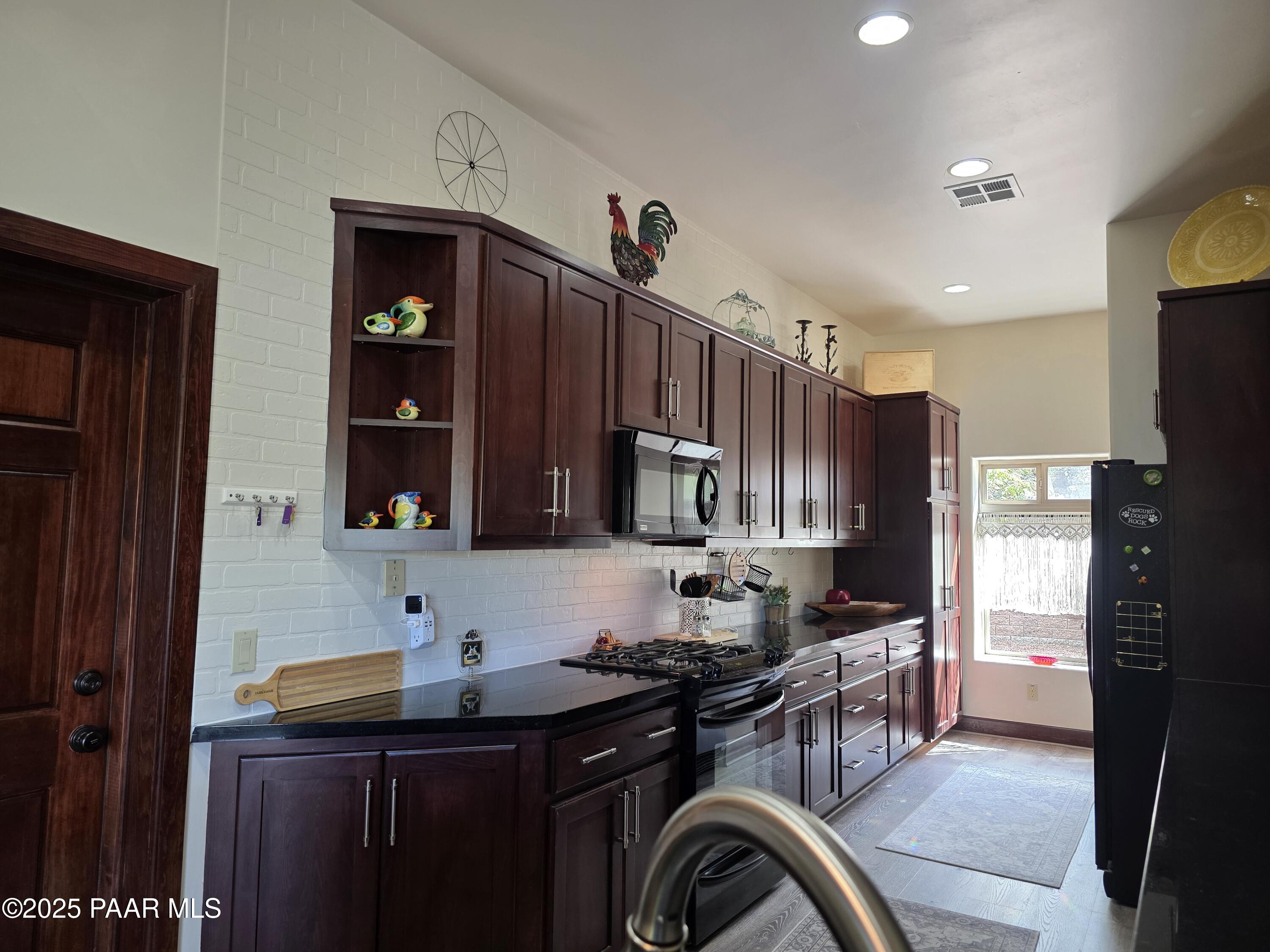 17180 West Model Creek Road Kirkland, AZ 86332 - Photo 12 of 53 a kitchen with stainless steel appliances granite countertop a sink stove and refrigerator