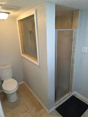 a bathroom with a toilet and a shower