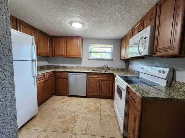 a kitchen with stainless steel appliances granite countertop a stove top oven sink and cabinets