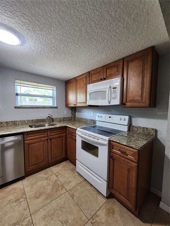4425 Fairview Avenue Orlando, FL 32804 - Photo 6 of 16 a kitchen with stainless steel appliances granite countertop a stove a sink and a microwave
