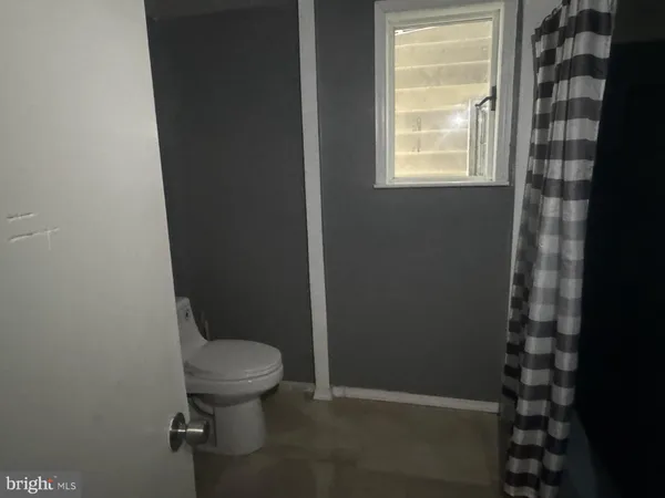 a white toilet sitting next to a window