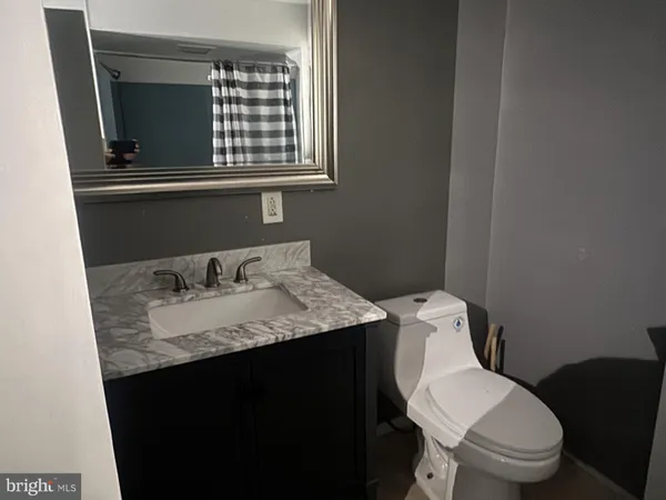 a bathroom with a granite countertop toilet sink and mirror