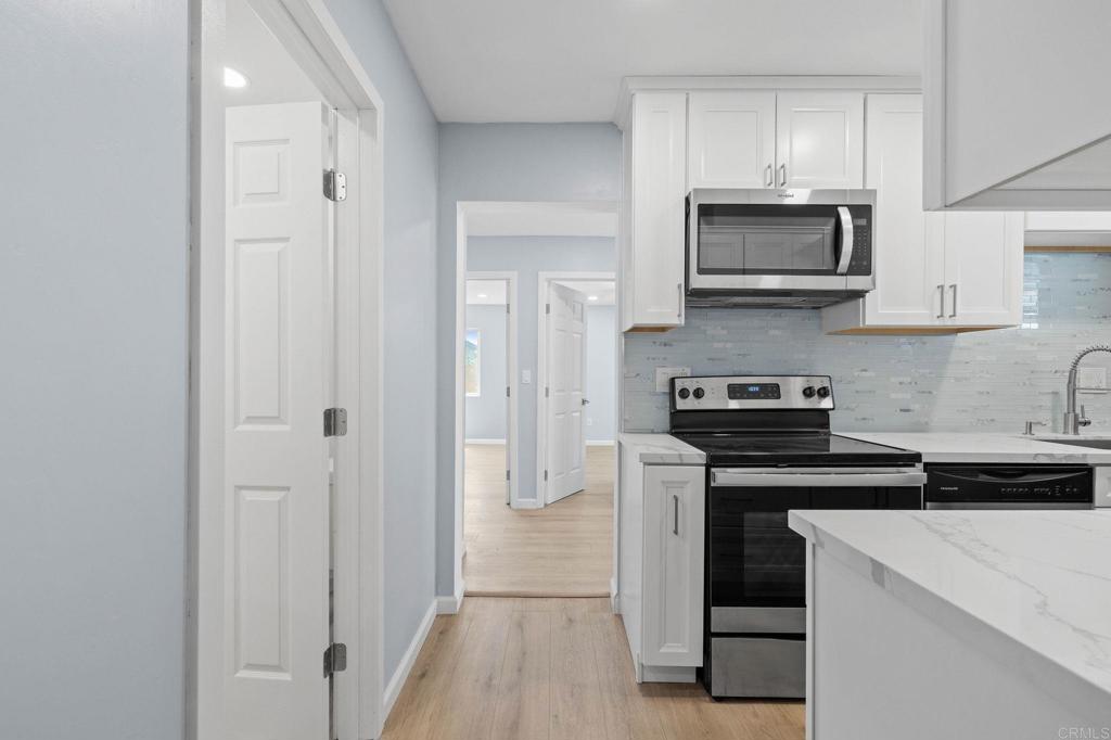 1908 Washington Street, Unit 2 Lemon Grove, CA 91945 - Photo 6 of 26 a kitchen with white cabinets and stainless steel appliances