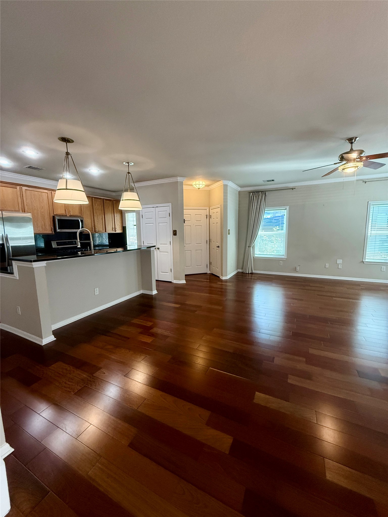 411 West St Elmo Road, Unit 39 Austin, TX 78745 - Photo 3 of 25 Gleaming hardwood floors and a spacious breakfast bar anchor this inviting open-concept living space.
