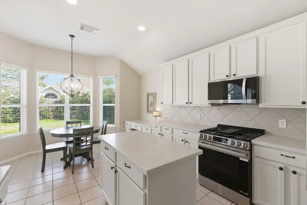 a kitchen with a stove a sink and a microwave