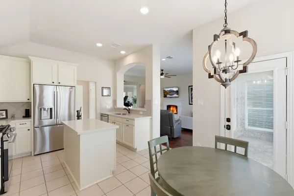 a kitchen with stainless steel appliances a refrigerator a sink a stove and white cabinets