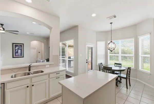 a room with a table chairs and couches