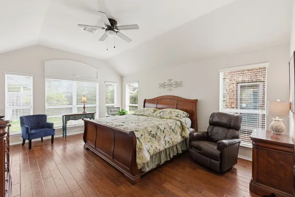 a bedroom with a bed couch and a large window