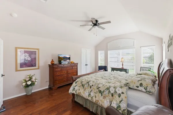 a bedroom with a bed and wooden floor