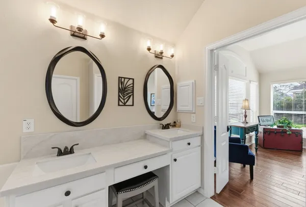 a bathroom with a granite countertop double vanity sink and a mirror