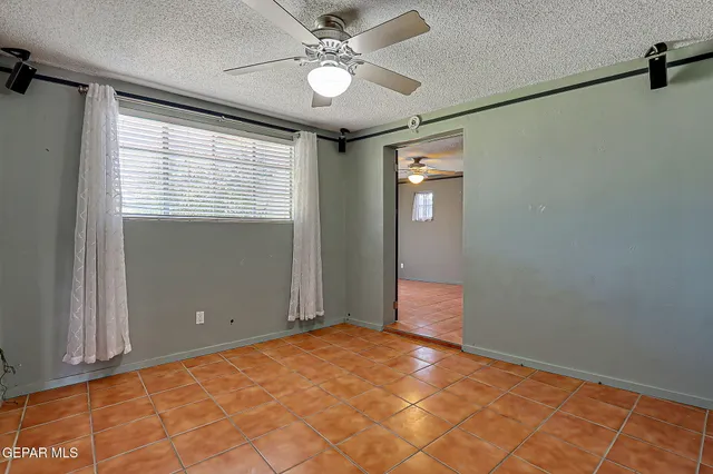 a view of an empty room with window and closet area