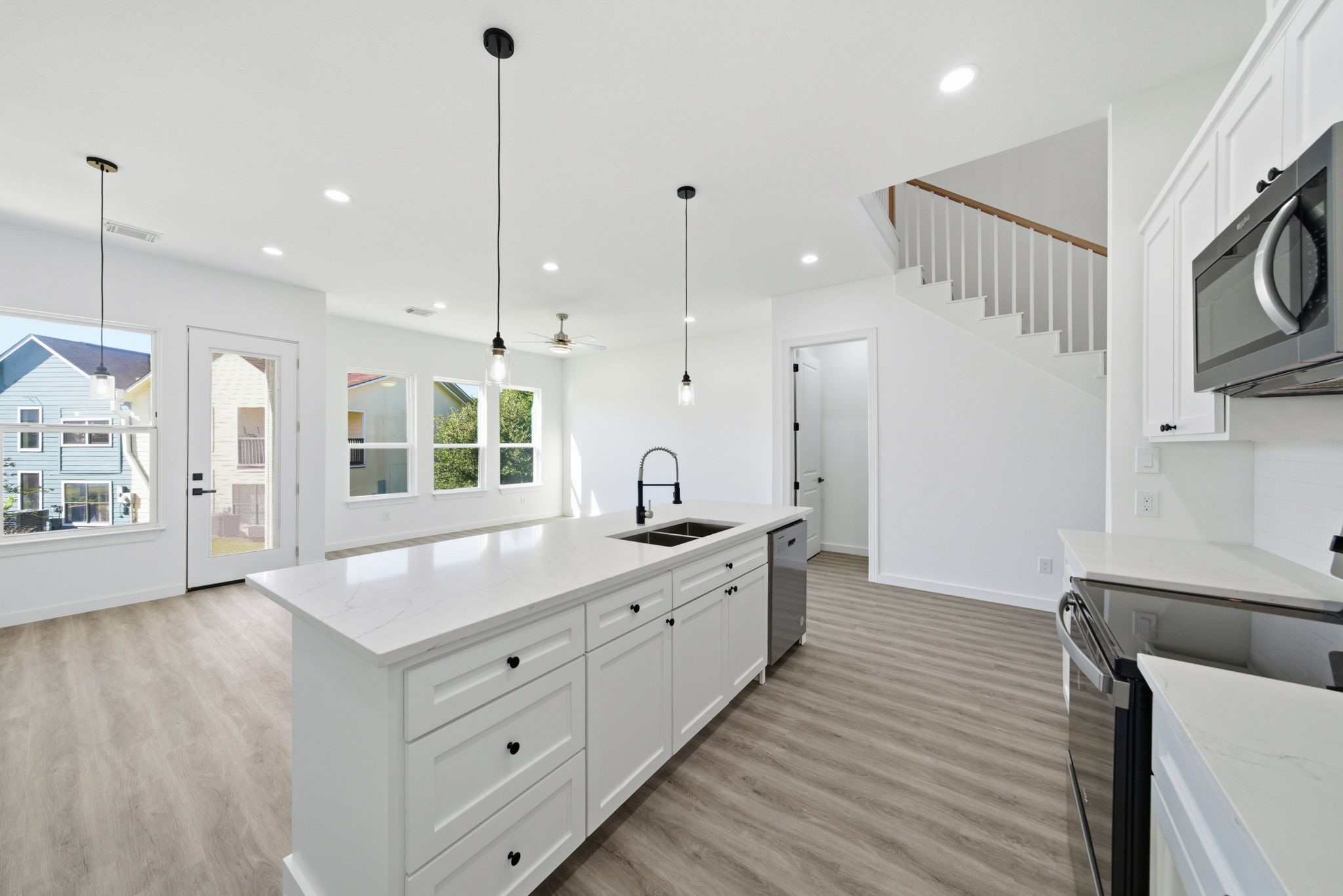 111 Capetown Way Conroe, TX 77356 - Photo 11 of 37 a large kitchen with kitchen island a stove a sink a center island and wooden floor