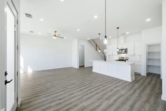 a view of kitchen with kitchen island white cabinets and stainless steel appliances