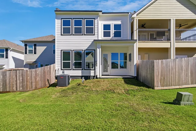 a view of an house with backyard space and wooden fence