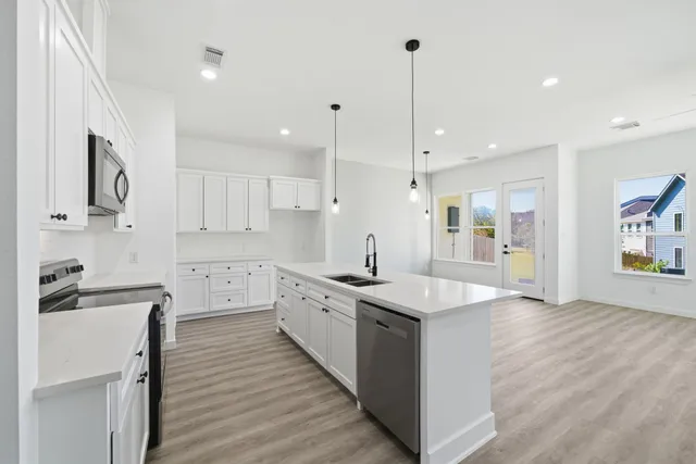 a large kitchen with stainless steel appliances kitchen island granite countertop a sink and cabinets