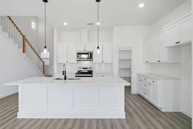 a kitchen with kitchen island white cabinets and white appliances