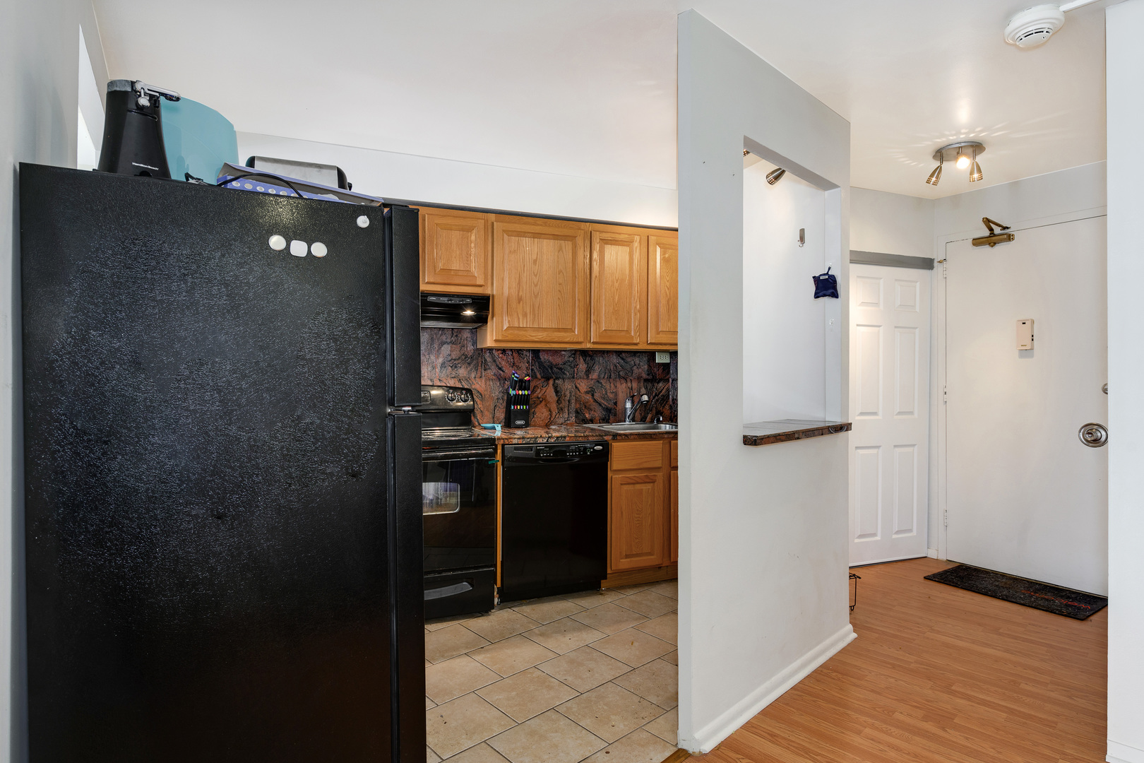 300 North State Street, Unit 3129 Chicago, IL 60654 - Photo 6 of 19 a kitchen with a refrigerator and cabinets