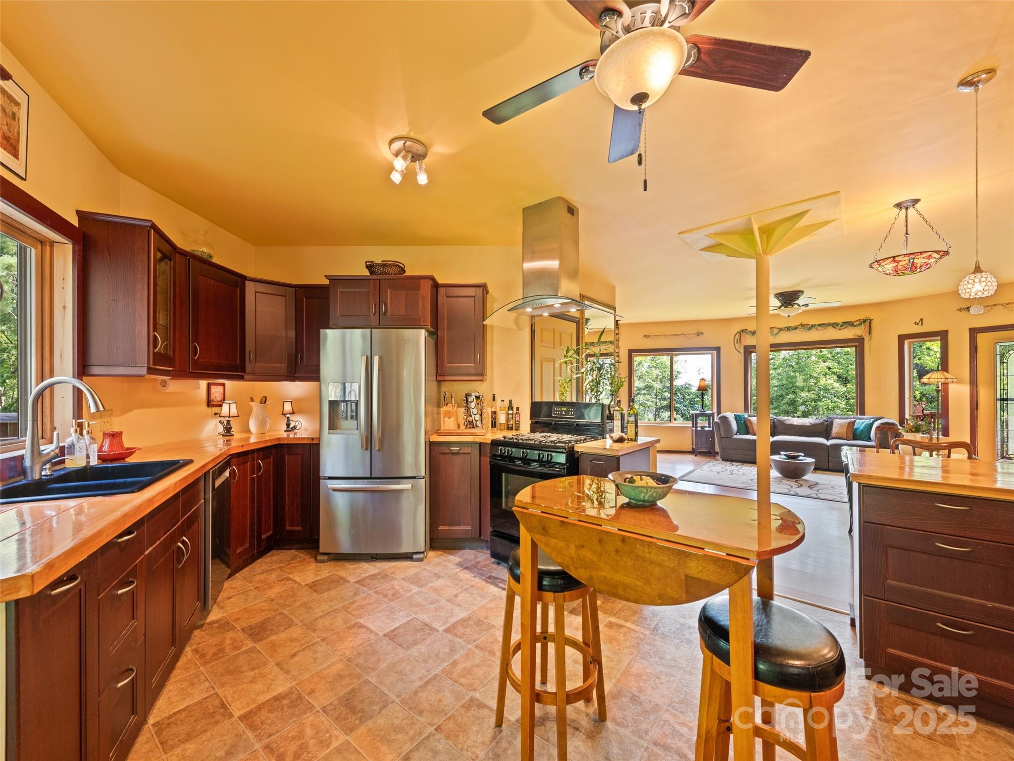2675 Holbert Cove Road Saluda, NC 28773 - Photo 22 of 48 a kitchen with stainless steel appliances kitchen island granite countertop a table chairs and a refrigerator