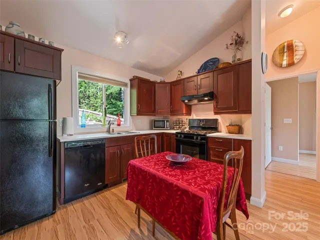 a kitchen with stainless steel appliances granite countertop a stove sink refrigerator and cabinets
