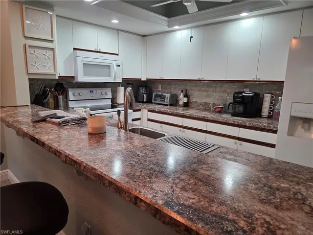 a large kitchen with stainless steel appliances granite countertop a sink a stove and cabinets