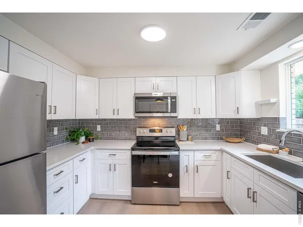 a kitchen with white cabinets and white appliances