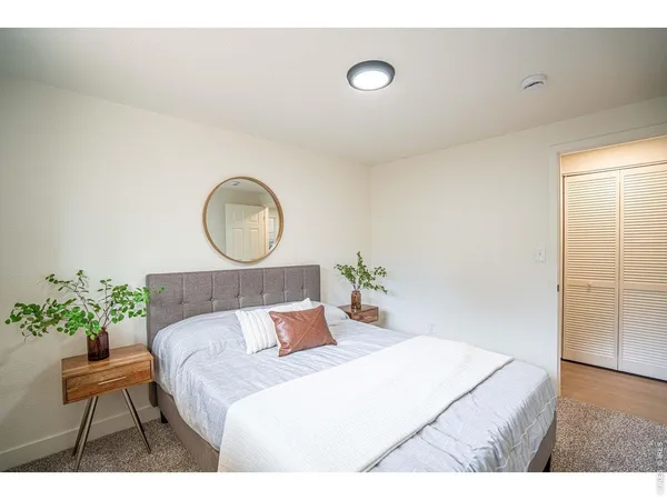 a bed room with a bed mirror and a potted plant