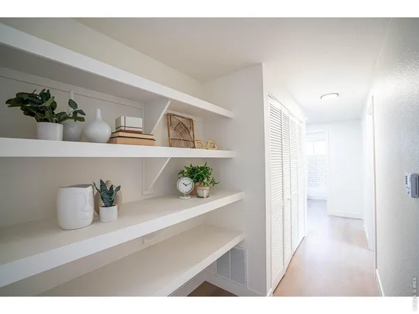a kitchen with a refrigerator and wooden floor