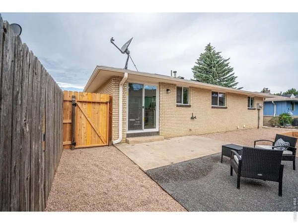 a backyard of a house with barbeque oven table and chairs