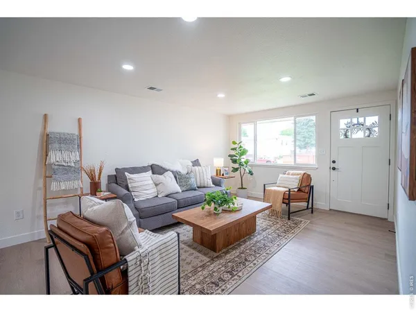 a living room with furniture and wooden floor