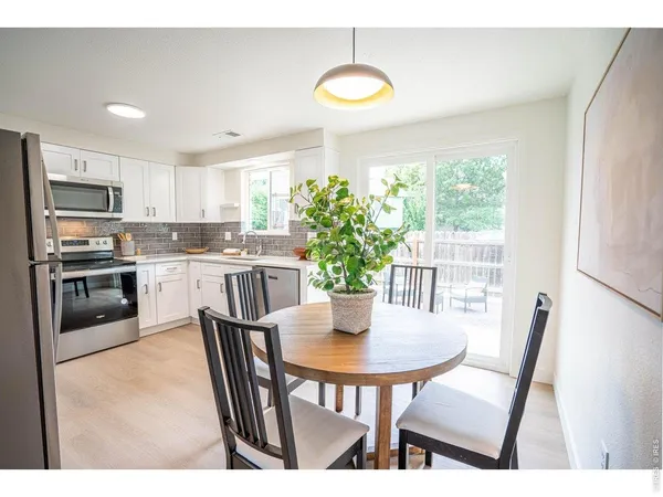 a kitchen with stainless steel appliances granite countertop a stove a refrigerator a kitchen island a stove a table and chairs