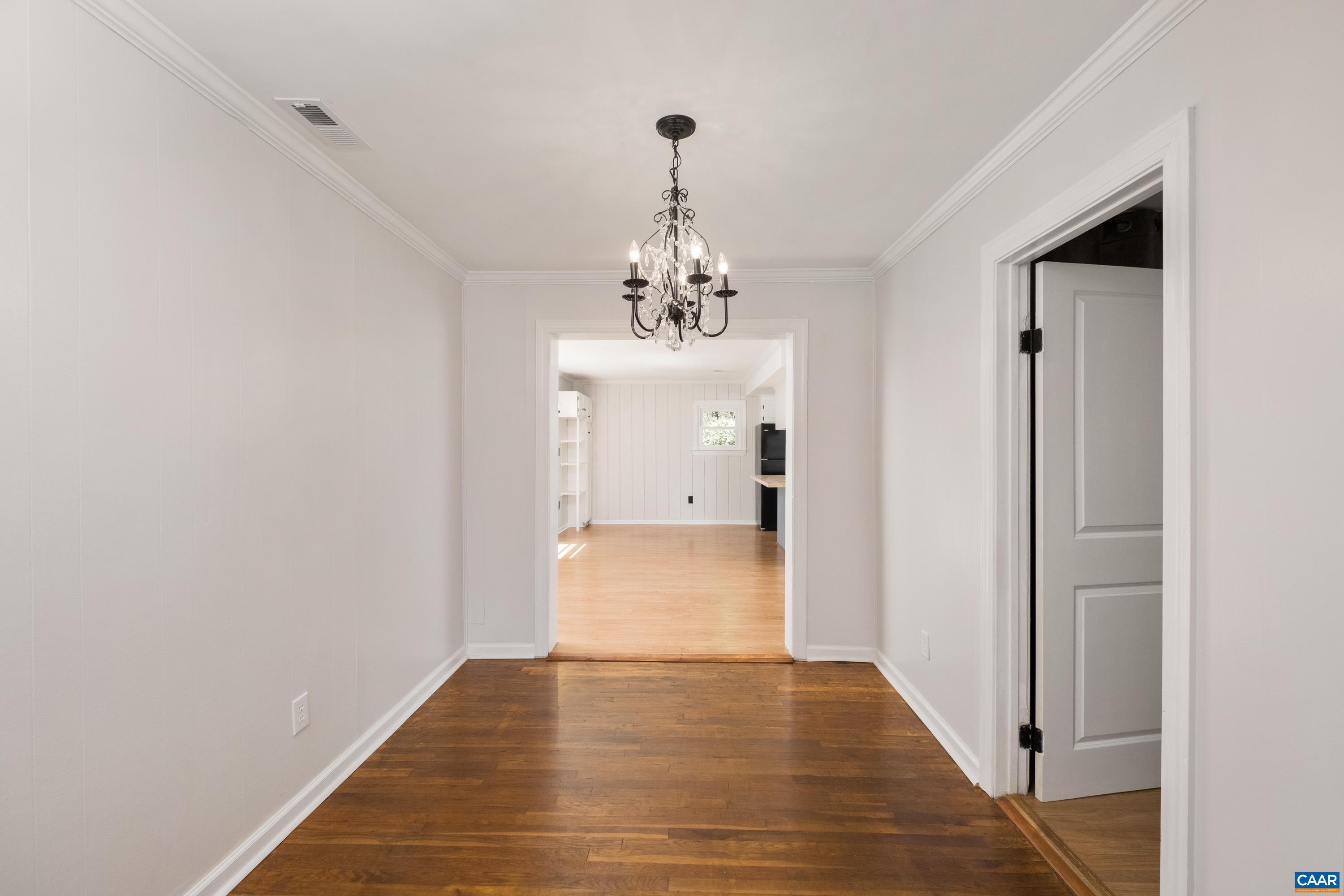 578 Maxfield Road Keswick, VA 22947 - Photo 11 of 39 a view of a hallway with wooden floor and a chandelier