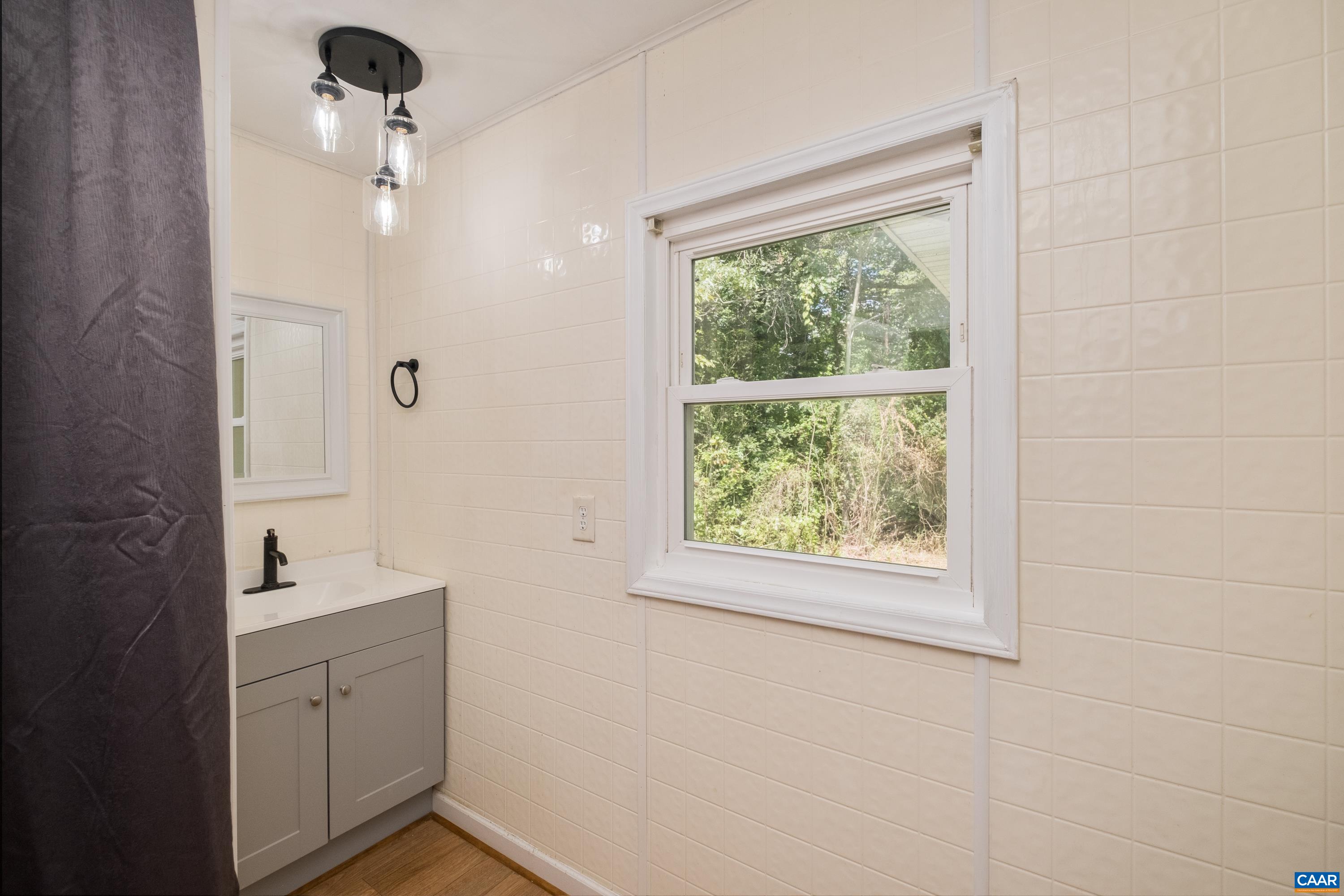 578 Maxfield Road Keswick, VA 22947 - Photo 12 of 39 a bathroom with a sink a large mirror and shower
