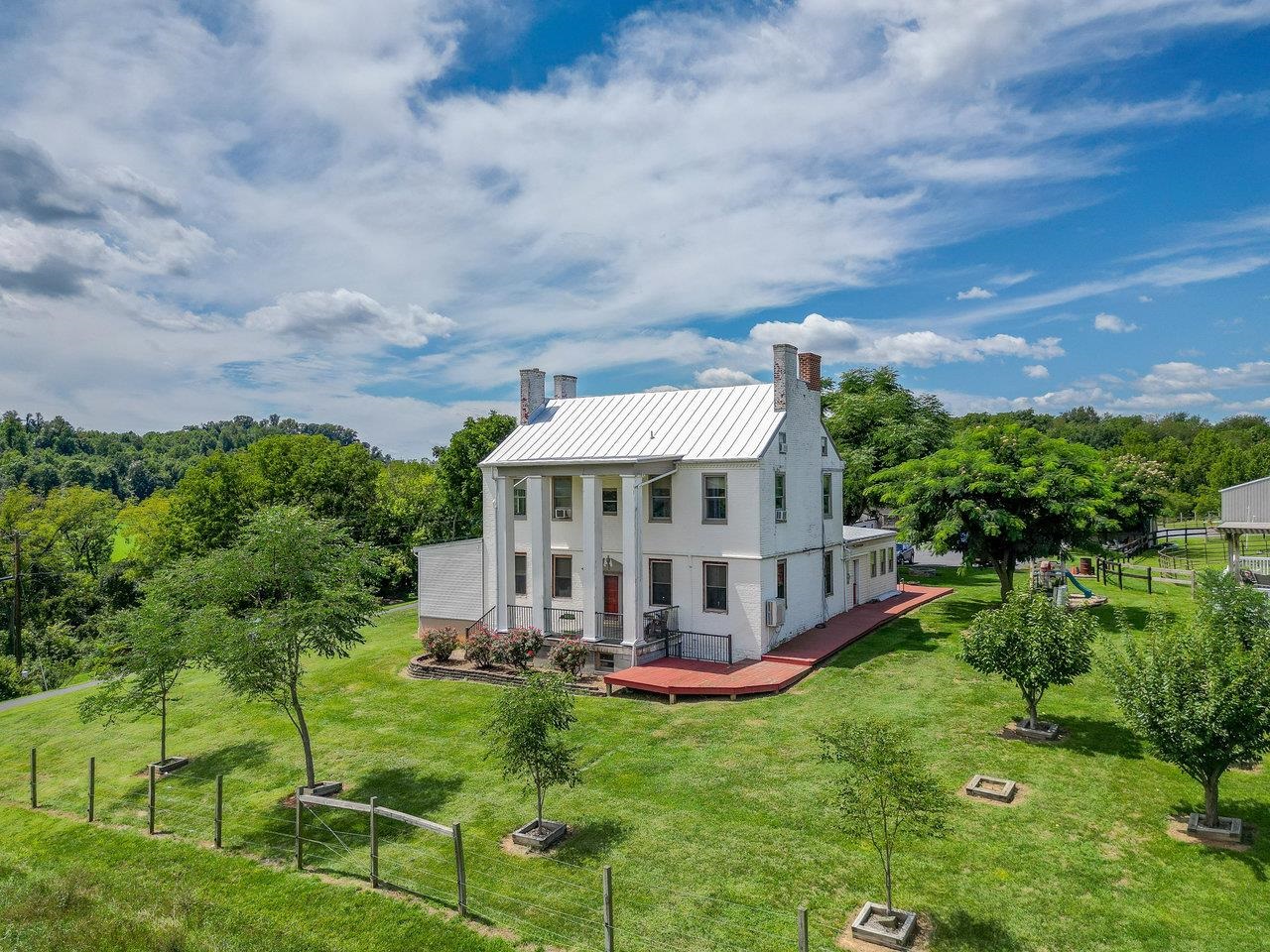 a view of a house with a big yard and large trees
