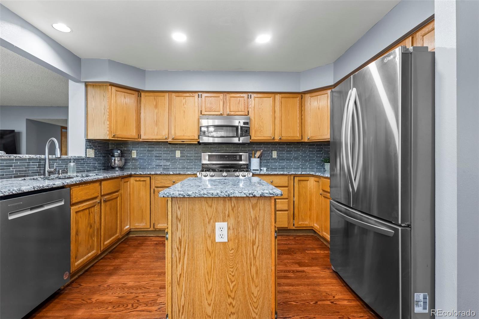 17538 East Baker Place Aurora, CO 80013 - Photo 11 of 50 a kitchen with stainless steel appliances granite countertop a refrigerator a sink a stove a washer dryer and a refrigerator